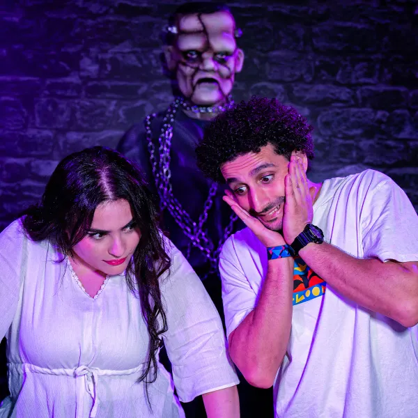 Zwei erschrockene Spieler, hinter ihnen ein angekettetes Monster in Magic Potion